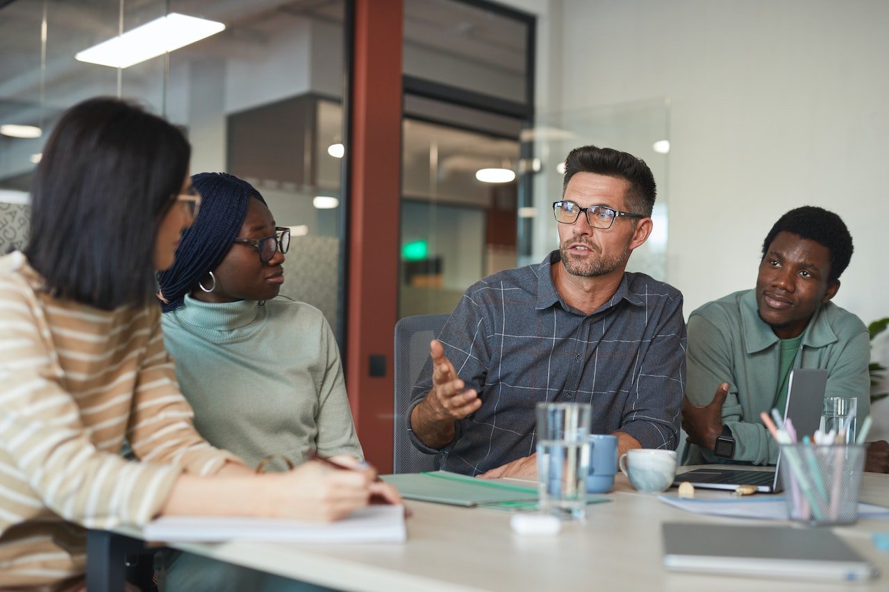 three-coworkers-looking-at-laptop-together-discussing-participative-leadership