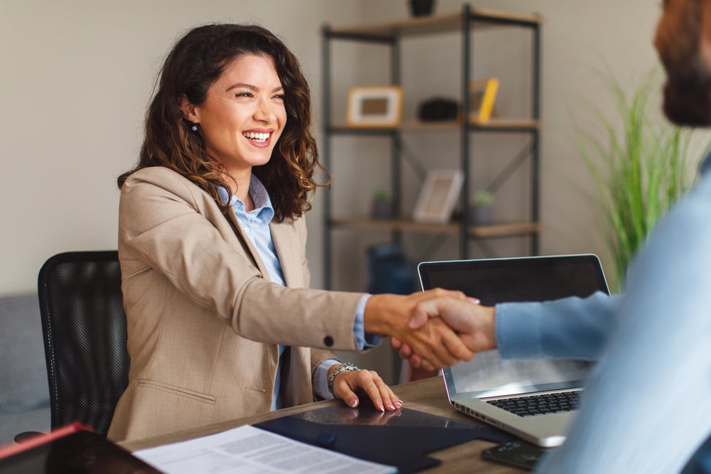 Young-woman-shaking-hands-with-employer-how-to-answer-salary-expectations